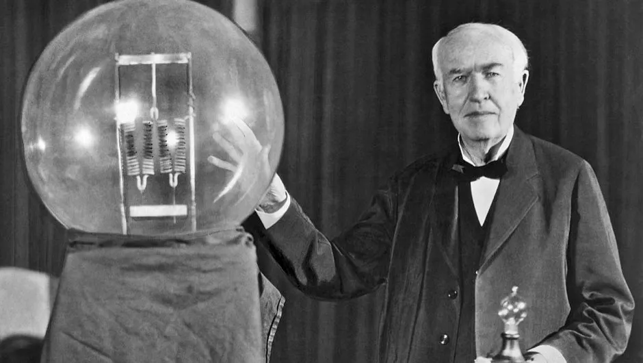 Thomas Edison holding his invented light bulb