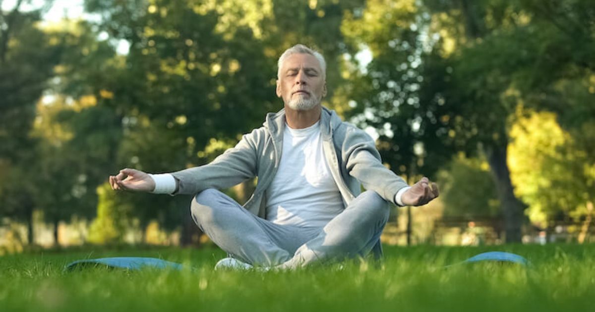 Person meditating in the present moment in a beautiful park