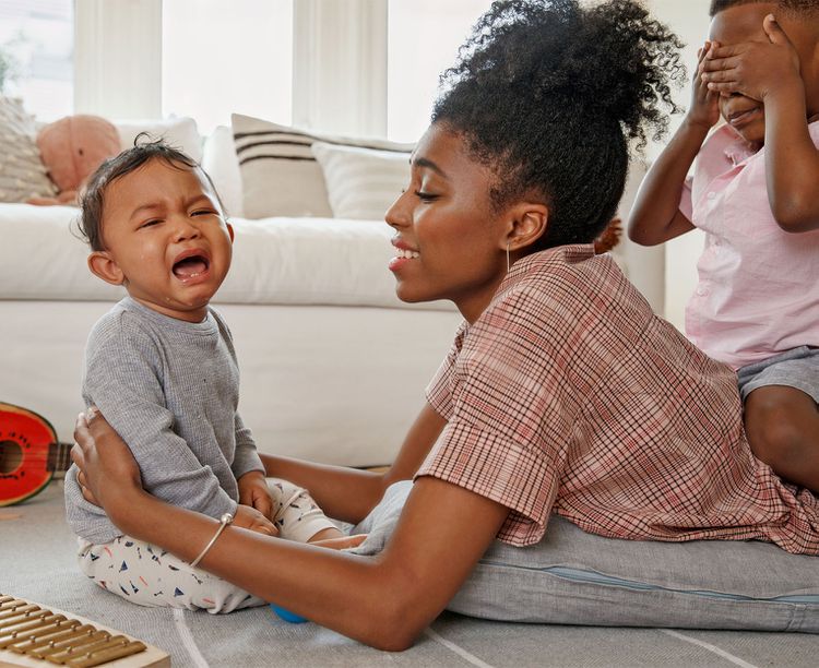 Mother compassionately comforts crying son